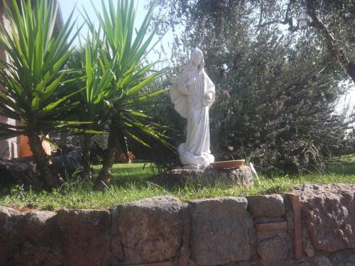 a statue of a woman standing next to a stone wall at Agriturismo Casal Grande in Canepina