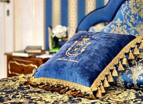 a blue pillow sitting on top of a bed at Hotel Villa Condulmer in Mogliano Veneto