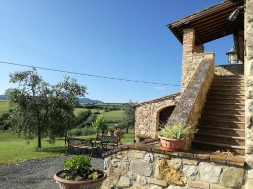 a stone house with a staircase and a bench at Casa il Ponte in Chianni