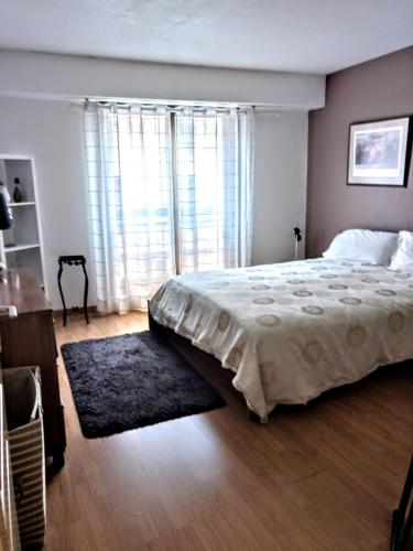 une chambre avec un grand lit et une grande fenêtre dans l'établissement Le Saint Roch, à Menton