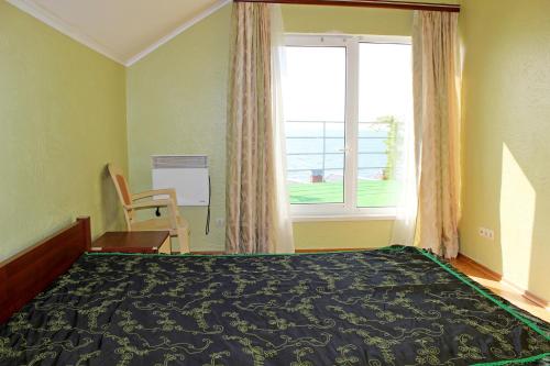 sypialnia z łóżkiem i dużym oknem w obiekcie Подвійний котедж з терасою біля моря Совіньон w Odessie