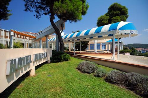 a building with a blue and white awning at Maistra Select Pineta Hotel in Vrsar