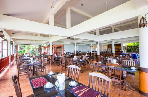 una sala da pranzo con tavoli e sedie in un ristorante di Lanta Casuarina Beach Resort - SHA Plus a Ko Lanta