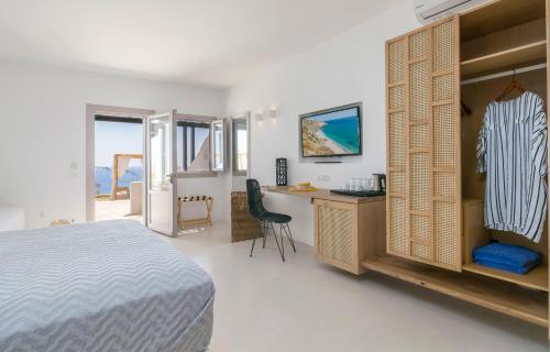 a bedroom with a bed and a desk and a deskablish at Psaravolada Hotel Milos in Agia Kiriaki Beach