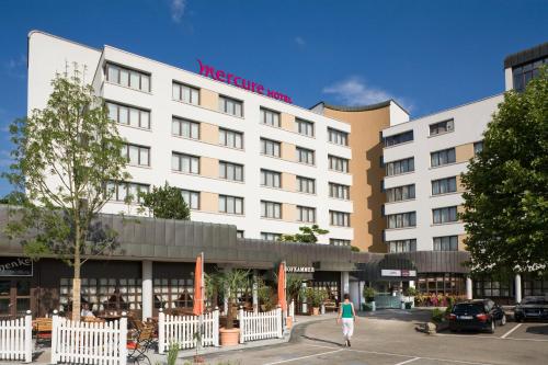 a woman walking in front of a hotel at Mercure Hotel am Messeplatz Offenburg in Offenburg