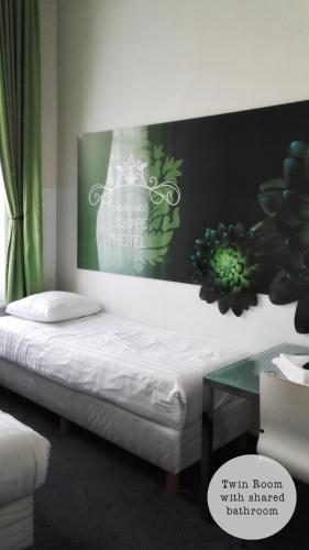 a bed in a room with a sign on the wall at Rembrandt Square Hotel in Amsterdam