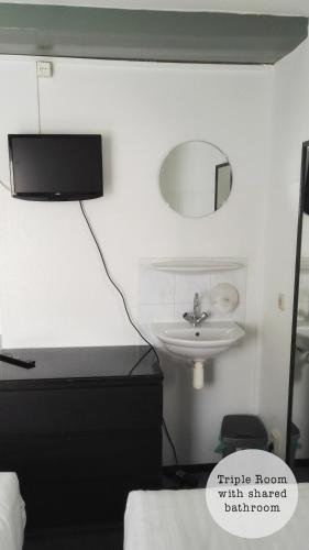 a bedroom with a sink and a mirror on the wall at Rembrandt Square Hotel in Amsterdam