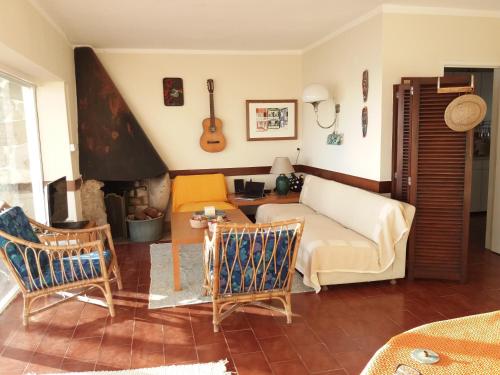 BombardeiraにあるGenuine Summer Houseのリビングルーム(ソファ、壁にギター付)