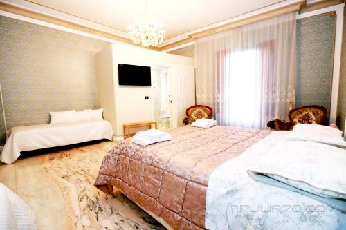 1 dormitorio con 2 camas y lámpara de araña en Apulia 70 Holidays, en Polignano a Mare