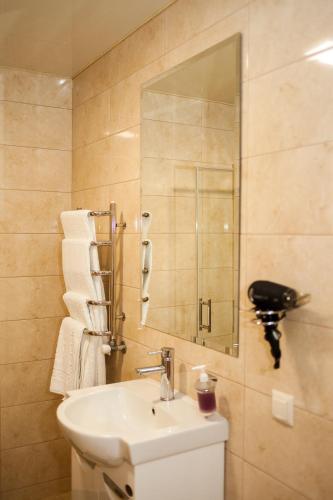 a bathroom with a sink and a mirror over a toilet at Charivne Ozero in Korostyshiv