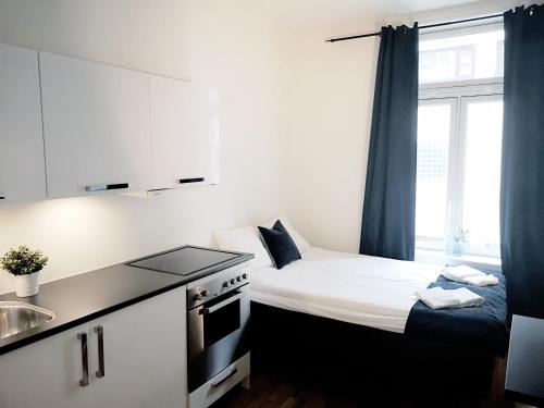 a small kitchen with a bed and a sink at Forenom Serviced Apartments Oslo Royal Park in Oslo