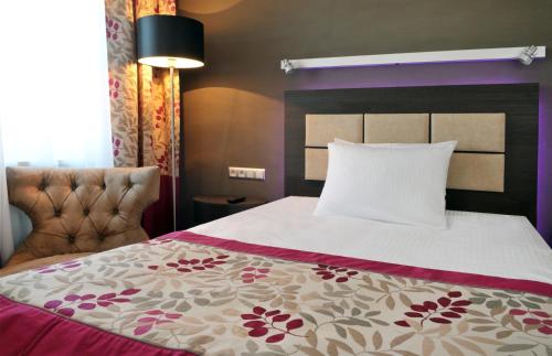 a bedroom with a bed with a white bedspread and a pillow at Hotel 3 Trio in Białystok