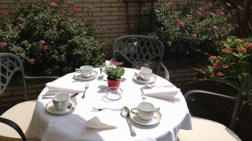 a white table with cups and saucers on it at Hotel Imperial in Cologne