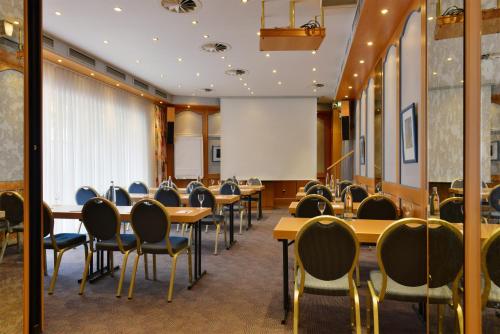 a conference room with tables and chairs and a whiteboard at Hotel Imperial in Cologne