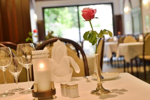 a table with a rose in a vase and a candle at Hotel Imperial in Cologne