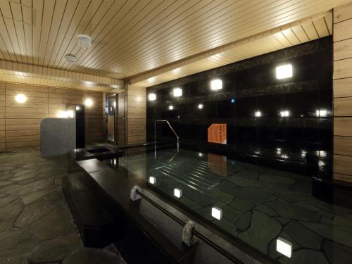 a swimming pool in a building with lights at APA Hotel Nagoya Sakae Kita in Nagoya
