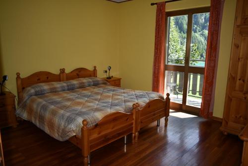 a bedroom with a bed and a large window at Albergo Mangusta in Madesimo