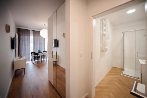a white apartment with a dining room and a table at Very Berry - Zwierzyniecka 30 - check in 24h, parking, lift in Poznań