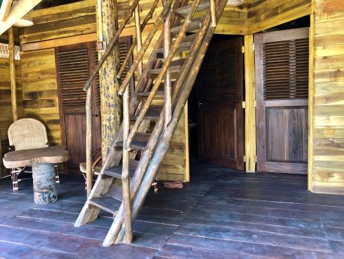 a wooden staircase in a cabin with a chair at Wind Blend Kite Resort in Kalpitiya