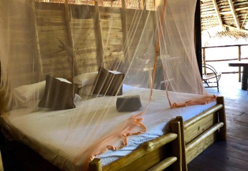 a bed in a room with a mosquito net at Wind Blend Kite Resort in Kalpitiya