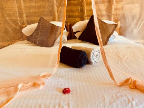 a red flower sitting on a white bed at Wind Blend Kite Resort in Kalpitiya