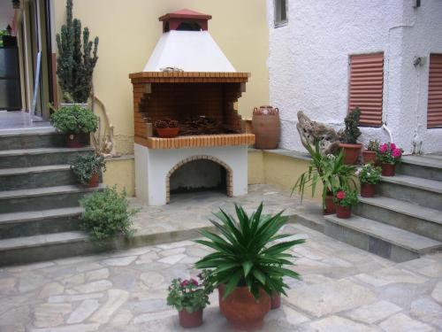 a outdoor fireplace with potted plants in a courtyard at The Delfini Hotel in Agia Marina Aegina
