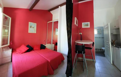 a red bedroom with a bed and a table at Les Cerisiers in Écully