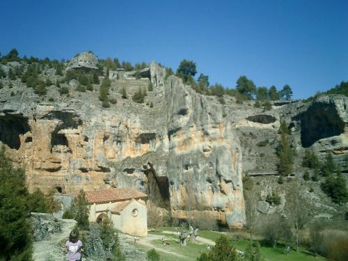 a small church in front of a rocky mountain at Casa Rural Cañón de Río Lobos II in Casarejos