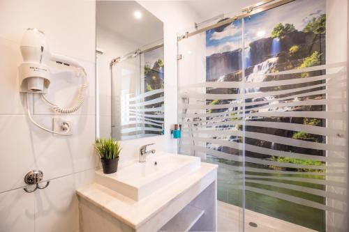 a bathroom with a sink and a shower at Residencial Mar e Sol in Costa da Caparica