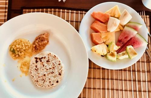 two plates of food with fruit on a table at Wind Blend Kite Resort in Kalpitiya