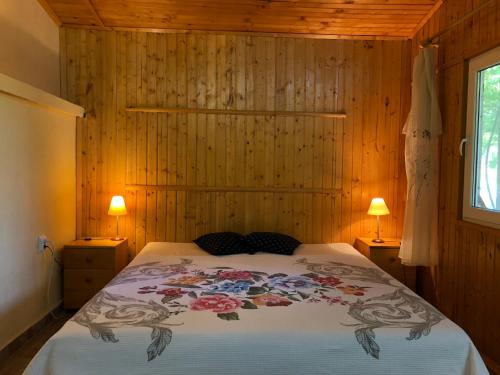 1 dormitorio con 1 cama en una pared de madera en Galeria In The Garden, en Plovdiv