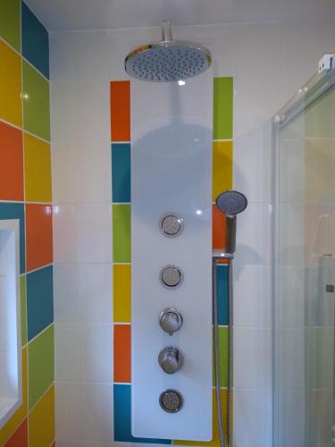 La salle de bains est pourvue d'une douche et de carrelage coloré. dans l'établissement La Maison Saint-Pry, à Béthune