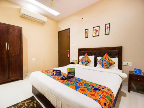 a bedroom with a bed with a colorful comforter at FabExpress Travelers Lodge in Jaipur