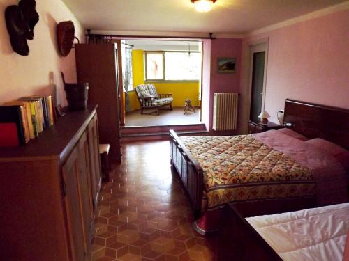 a bedroom with a bed and a chair in a room at l'Oca Mannara in Ameno