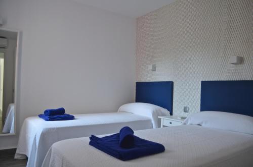 a room with two beds with blue towels on them at The Peaches Bungalows 45 & 46 in Maspalomas