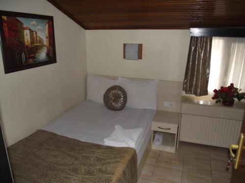 a small bedroom with a bed and a window at Olimpiyat Hotel Izmir in Izmir