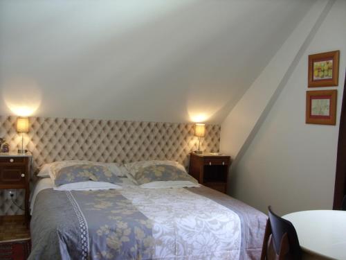 um quarto com uma cama grande com lençóis azuis e brancos em Marcia Donatti-A l'Ombre des Coteaux Rio de Janeiro em Kaysersberg