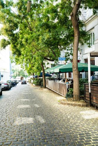 a cobblestone street with trees and parked cars at Hotel Marc Aurel - Vienna City Center in Vienna