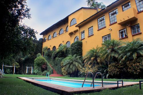 een zwembad voor een gebouw bij Casa Madero Rooms in Cuernavaca