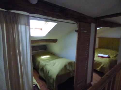 Balanodにあるgite le margueriteのベッド2台と窓が備わる小さな客室です。