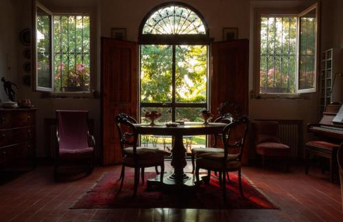 a dining room with a table and chairs and windows at Cà Morari in Argenta