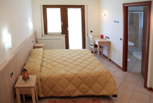 a bedroom with a large bed and a bathroom at Camere Rufino in Collestrada