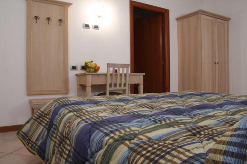 a bedroom with a bed with a blue and yellow blanket at Camere Rufino in Collestrada