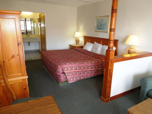 um quarto de hotel com uma cama e um espelho em Executive Lodge Absecon em Absecon