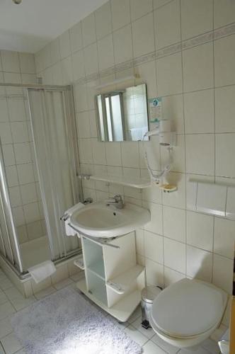 a bathroom with a toilet and a sink and a shower at Hotel KRONE Kressbronn am Bodensee in Kressbronn am Bodensee