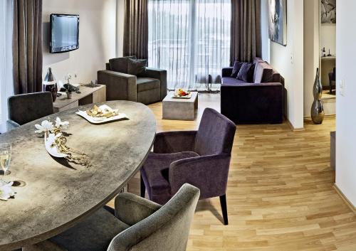 uma sala de estar com uma grande mesa e cadeiras em Art Hotel Superior em Aachen