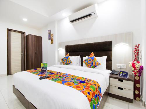 a bedroom with a large bed with a colorful blanket at Green Lotus Residency Dwarka in New Delhi