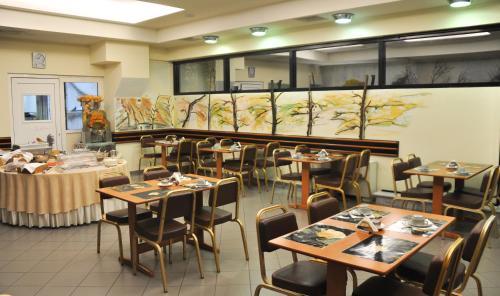 a dining room with tables and chairs in a restaurant at Hotel Metropol in Larisa