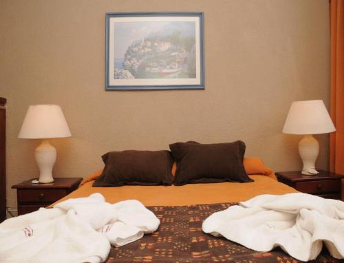 a bedroom with a bed with towels on it at Village Catedral Hotel & Spa in San Carlos de Bariloche