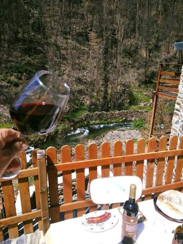 a person holding a glass of wine at a table at Casa do Moinho Novo in Fontão Fundeiro
